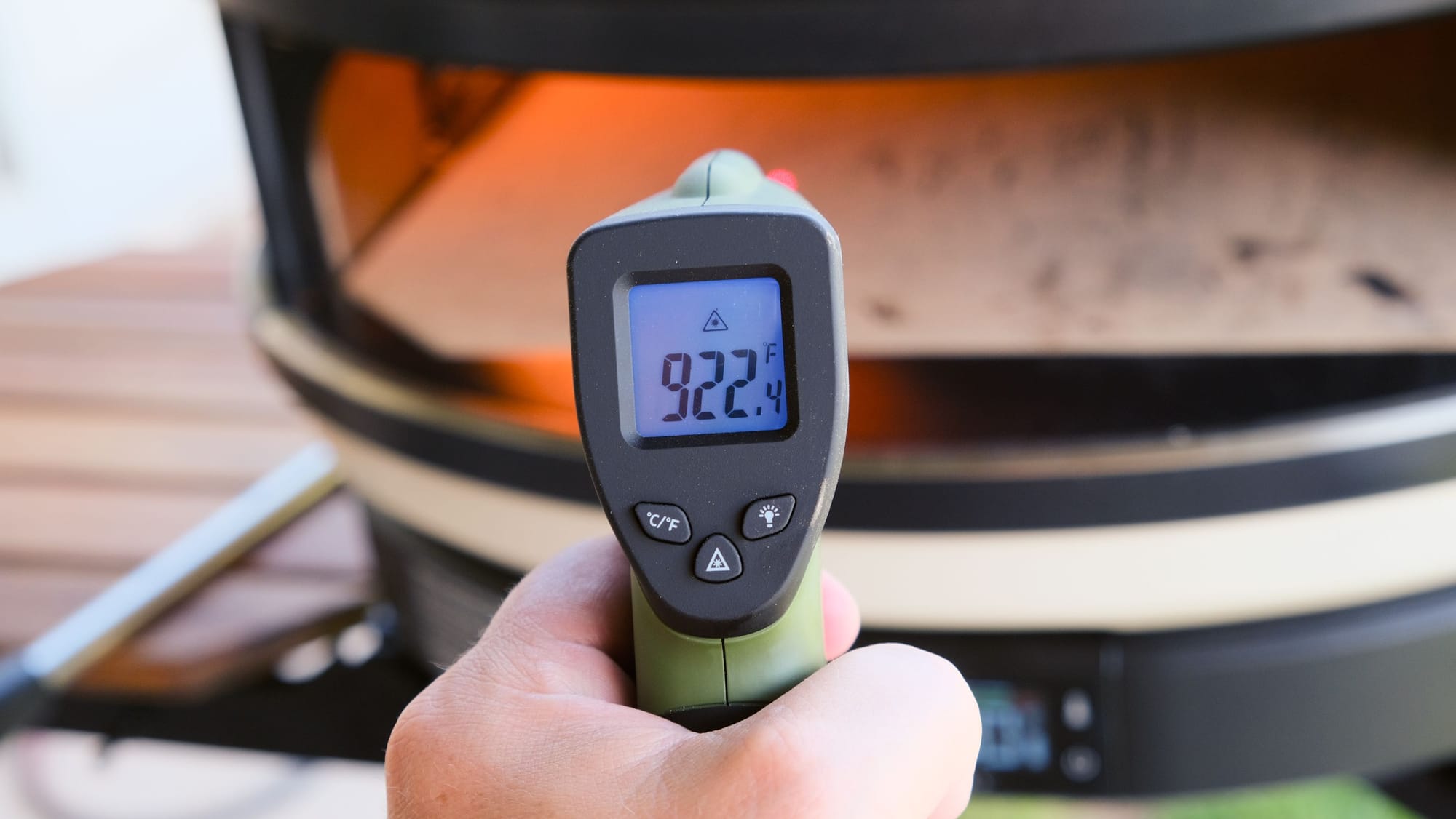 A hand holding an infrared thermometer showing a stone temperature of 922.4 degrees Fahrenheit inside the Gozney Arc XL.