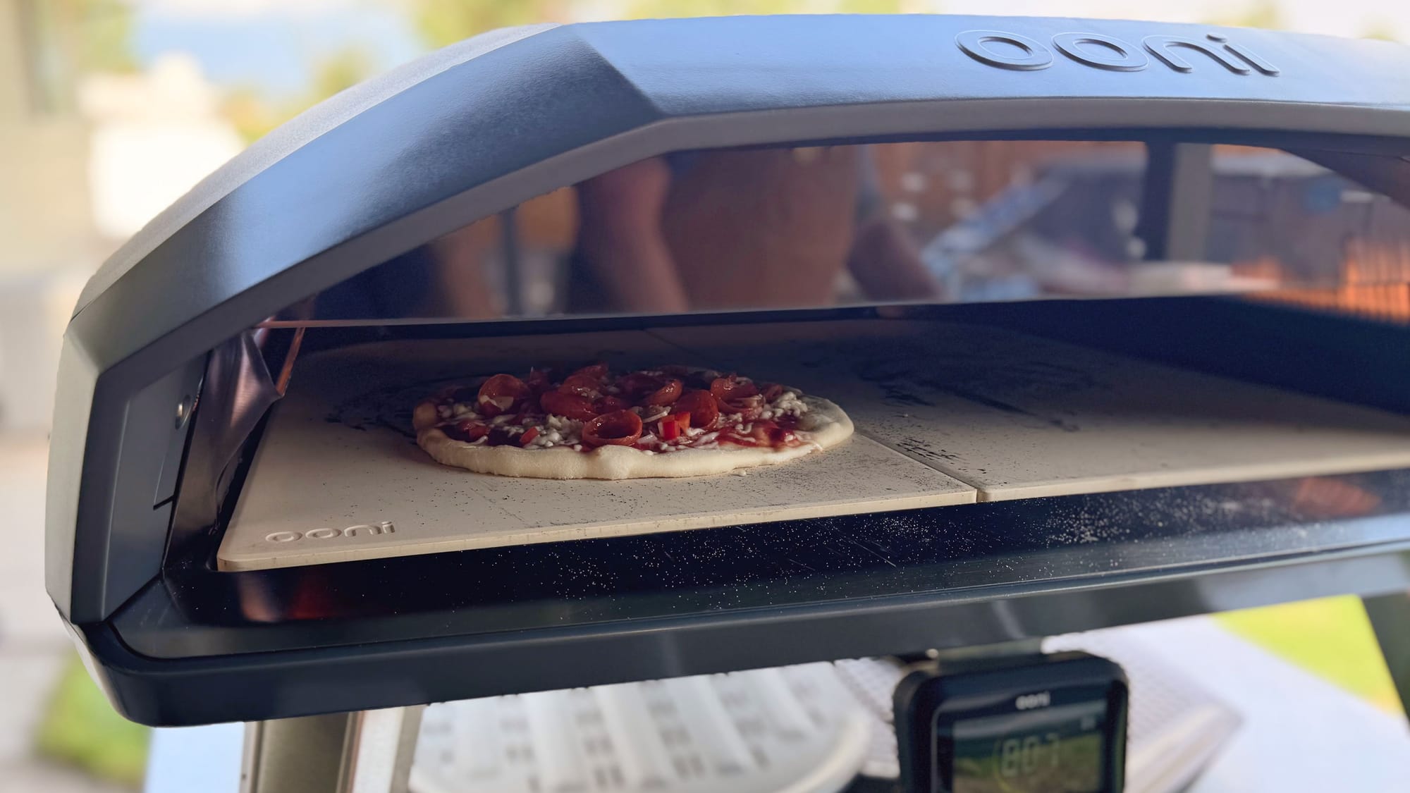 Close-up of a pepperoni pizza cooking on the split stone baking board inside the Ooni Koda 2 Max oven.